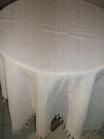 Beautiful white patterned tablecloth with fringed edges