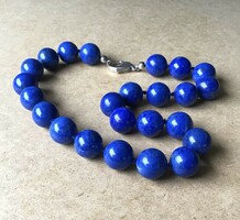 A row of large-eyed lapis lazuli beads with a silver clasp