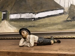 Old ceramic figure daydreaming boy.