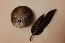 2 bronze-colored brooches together