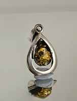 Silver pendant decorated with green amber