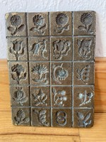 A plaque decorated with bronze flowers