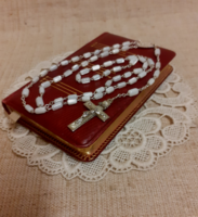 Old German language leather bound prayer book with gilt edges and mother of pearl rosary on lace tablecloth together