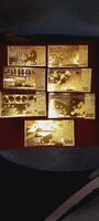 A row of 7 gold-plated, plastic pieces.