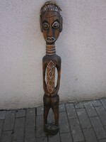 A large, carved, painted African statue made of wood. An interesting, showy piece.