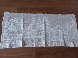 Old, hand-crocheted stained glass curtain with houses
