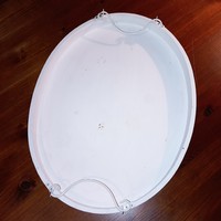 Oval shaped wooden tray with metal tabs.
