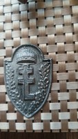 A shield-shaped souvenir made of metal