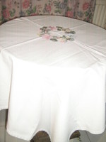 White woven tablecloth with beautiful cross-stitched wreath of flowers