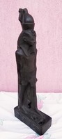 Black pharaoh standing statue in a circle with Egyptian symbols and hieroglyphs