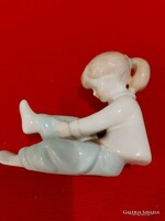 Aquincumi porcelán figura,zoknit húzó kislány.