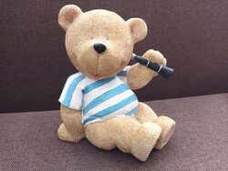 Large old, retro teddy bear in a striped t-shirt with binoculars