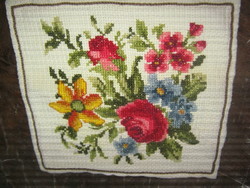 Decorative cushion with pink flowers sewn with beautiful cross-stitch embroidery