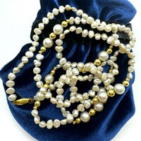 A long string of freshwater pearls with gold inlays