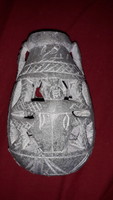 A small pot carved from antique sandstone with a figure and hieroglyphs is an Egyptian ornament according to the pictures