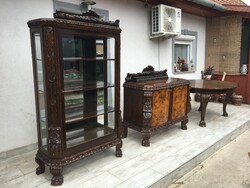 Richly carved display cabinet with lion feet.