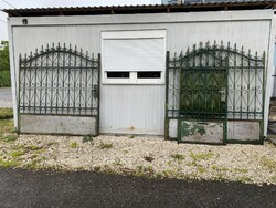 A three-leaf wrought iron gate with an arched roof is four meters long plus a small gate of one meter.