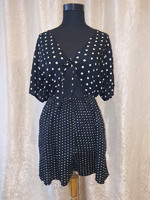 S-shaped polka dot jumpsuit with a tie in the front.