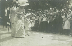 1912 – Előkelő hölgy, unokájával egy rendezvényen gyerekek között.