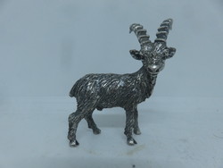 Small silver sculpture shaped like a mountain goat