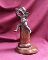 Cupid seated on a column. Antique table decoration. 19th century.