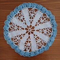 Round knitted-crochet placemat in white and blue colors with 3d border