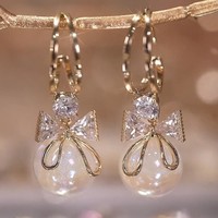Pale yellow gold earrings, decorated with pearls and crystal stones. Beautiful plug-in jewelry.