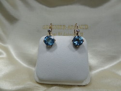 Rose gold earrings with a pair of blue topaz and glasses
