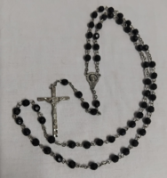 An old rosary prayer chain with a crucifix made of black grinding eyes