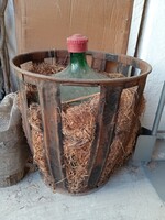 Régi üvegballon, bor, pálinka stb. tárolására alkalmas, szalmával bélelt fém védőkosárral együtt.