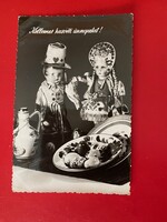 Régi,fekete-fehér húsvéti képeslap. Magyaros ruhába öltözött babákkal és hímes tojásokkal. Írott.