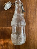 Retro,régi,rücskös,színtelen üdítős,csatos üveg. 2,5 dl-es A gumi és a porcelán kissé sérült.