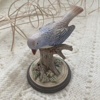 Jelzett, vitrinben tartott matt kék madár