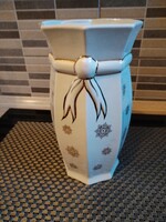 Witeg Köporc neobaroque bowtie vase – 25 cm. Description: An imposing, 25cm tall white stoneware vase from the Kőbánya Porcelain Factory (Witeg/Köporc) workshop. The body is decorated with elegant, gilded embossed bowtie and small rosette patterns. Despit