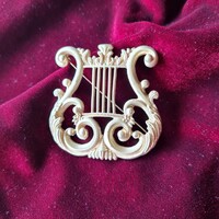 Elegáns aranyszínű hárfa bross.