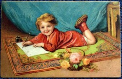 Antik litho képeslap   -  szőnyegen fekvő, levelet író vidám kisfiú