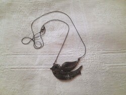 Eye-catching, bronze-colored long necklace with a delicate bird-shaped pendant.