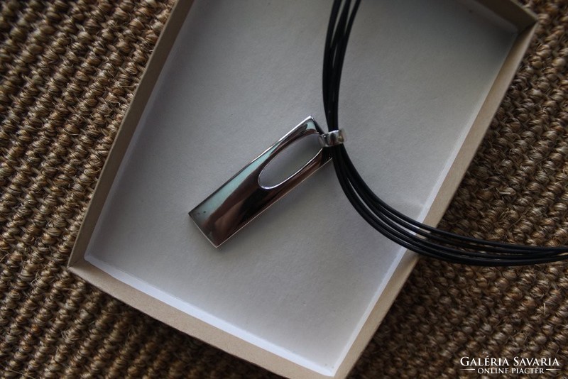 Silver pendant on rubber necklace