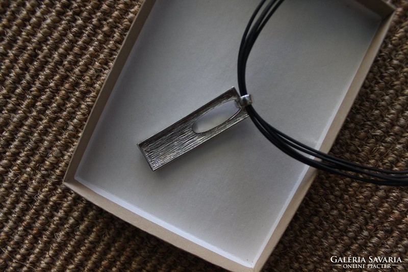 Silver pendant on rubber necklace