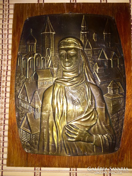 Beautiful Russian copper relief on a wooden background