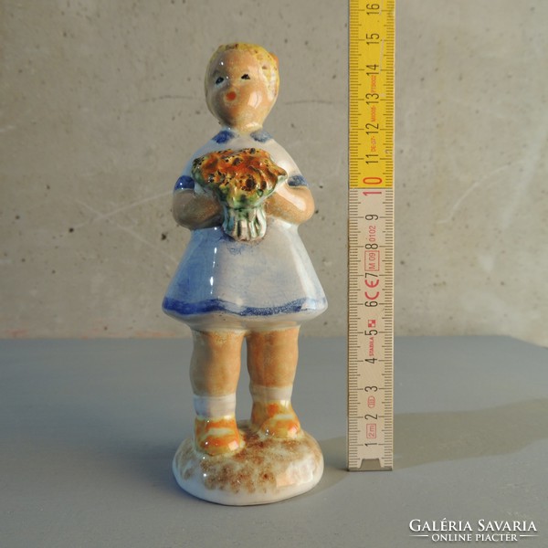 Glazed ceramic figurine of a little girl with a bouquet of flowers