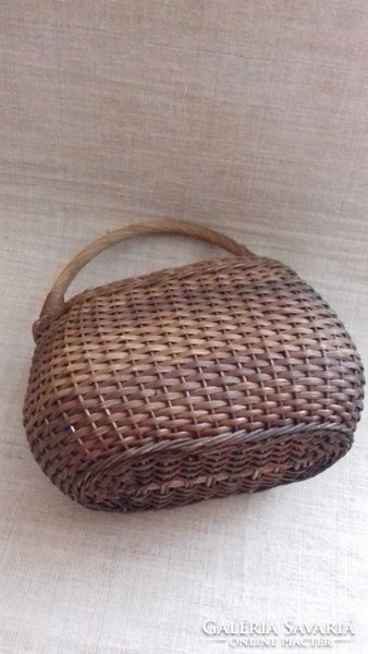 Old small-sized children's hand-woven basket with small canvas rubber interior.