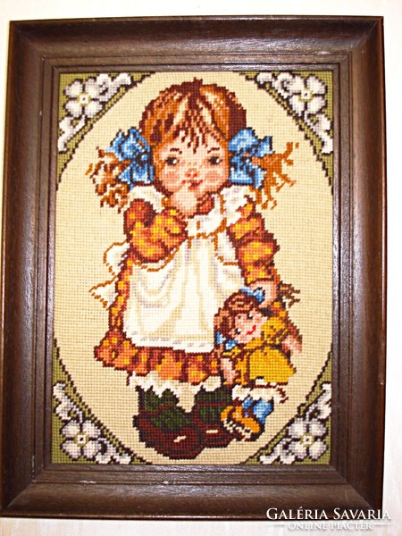 Little girl with baby framed by hand tapestry