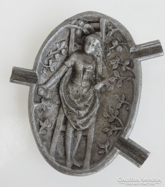 An old, plastically bulging ashtray made of aluminum: a woman picking fruit