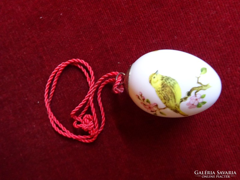 Porcelain egg with bird motif. With hanging cord. He has!