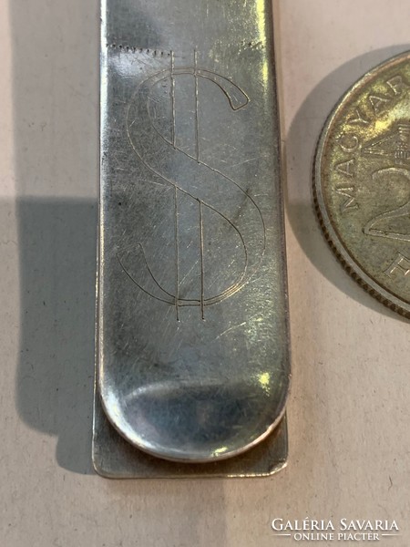 Silver money clip with dollar sign