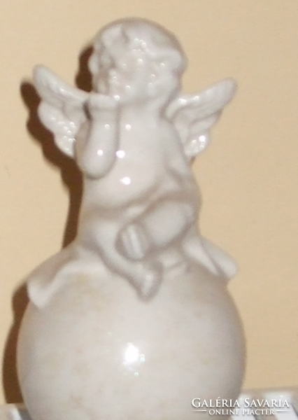 An angel sitting on a sphere sending a kiss