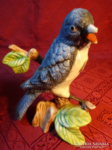 Porcelain figurine with a blue feathered bird on a tree branch, height 12.5 cm. He has!
