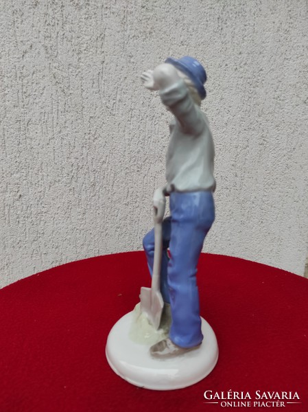 Porcelán figura, nehéz a munka,kalapos fiú àsóval 