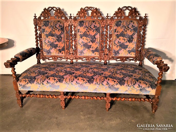 Old antique, richly carved renaissance style sofa